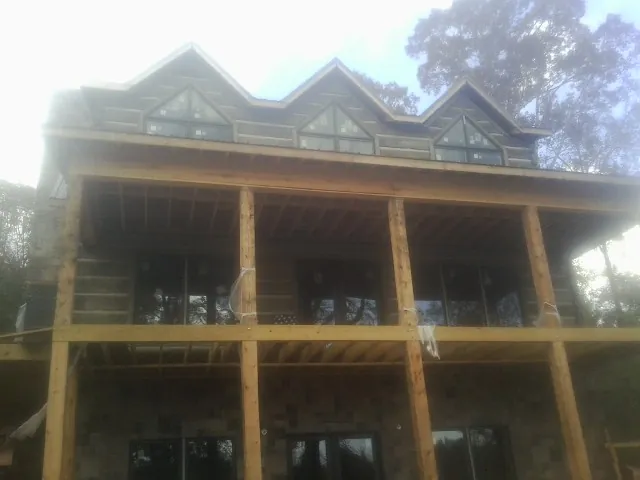 Dormers and porch framing on a large log home under construction — Roof Coating work by our crew in Cecil